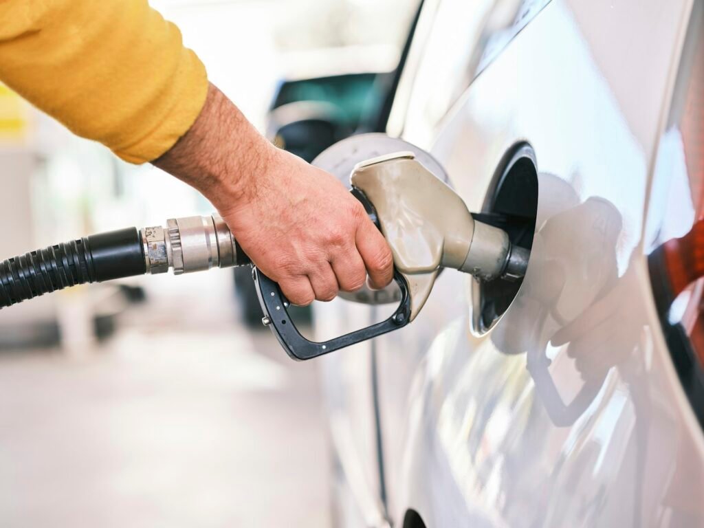 Conductor repostando gasolina en una estación de servicio